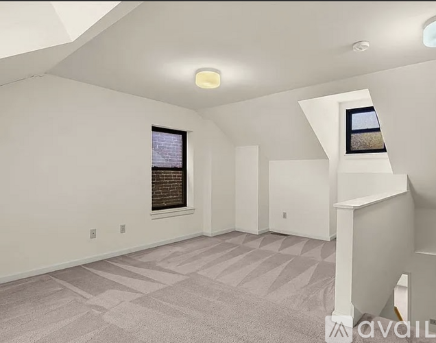 A spacious room with a carpeted floor and a window.
