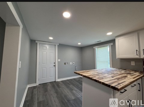 A kitchen with a wooden countertop and white cabinets.