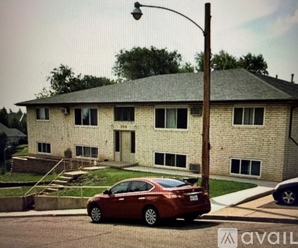 A red car is parked in front of a house.