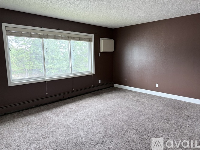 A room with brown walls and a window with blinds.