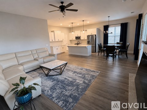 A living room with a white couch and a dining table.
