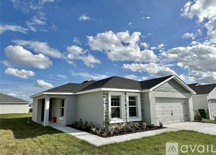A house with a front yard and a garage is available for sale.