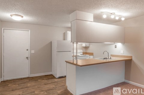 A kitchen with a white fridge and a white door.