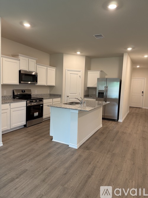 A kitchen with a granite countertop and stainless steel appliances.