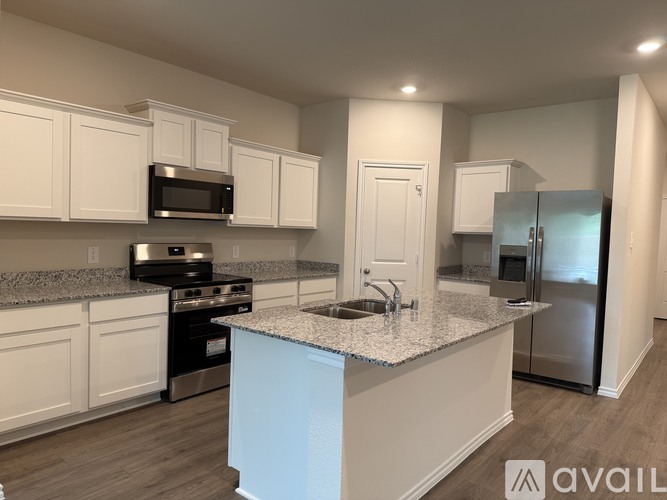 A kitchen with white cabinets and a granite countertop.
