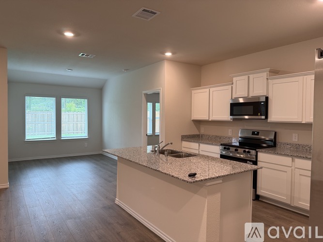 A kitchen with white cabinets and a granite countertop.