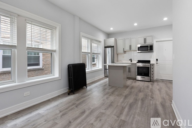 A spacious kitchen with a black rolling suitcase on the floor.