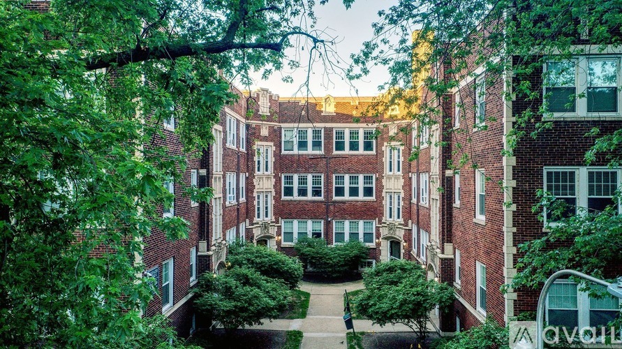 A large brick building with a courtyard surrounded by trees.