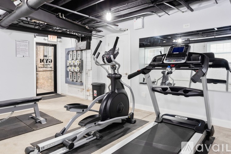 A treadmill and a stationary bike are in a gym.