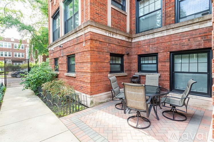 A brick building with a patio and chairs.