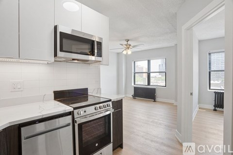 A kitchen with white cabinets and a black stove top oven.