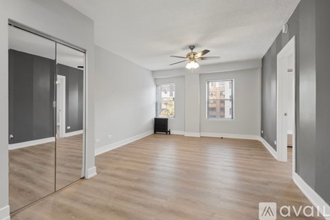 A spacious room with a ceiling fan and sliding glass doors.