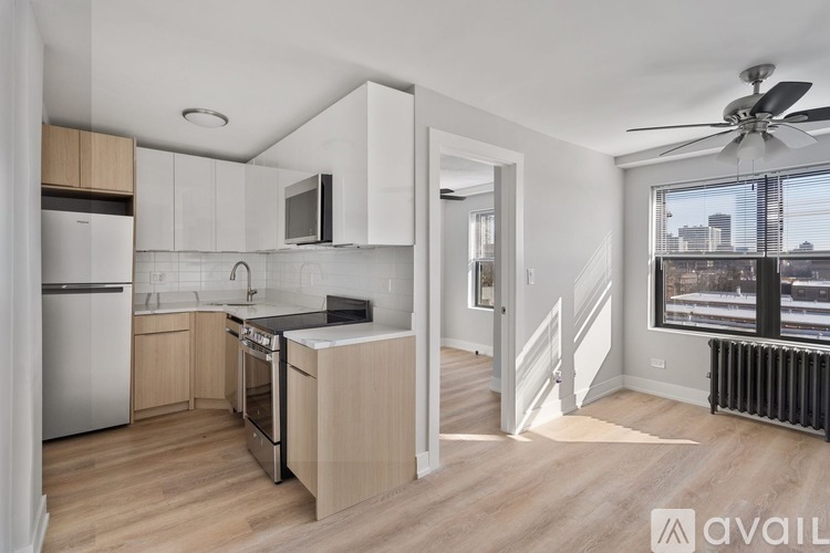 A kitchen with wooden floors and a stainless steel refrigerator.