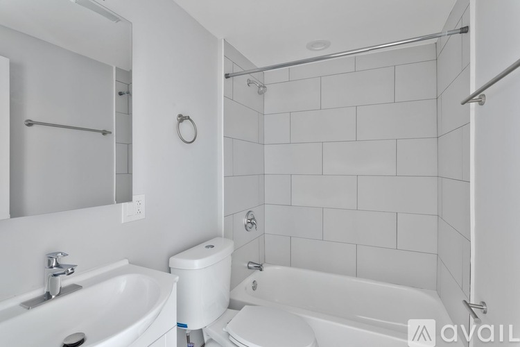 A white bathroom with a toilet, sink, and bathtub.