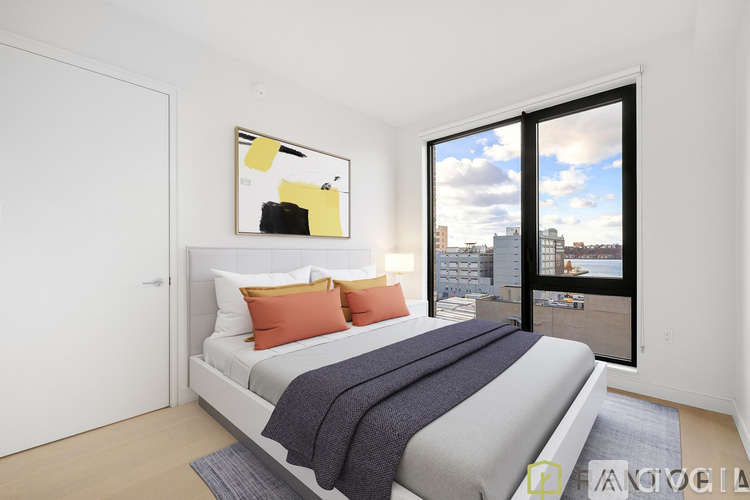 A bedroom with a large bed and a view of the city through the window.