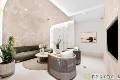 A modern living room with a green couch, a white coffee table, and a large painting on the wall.