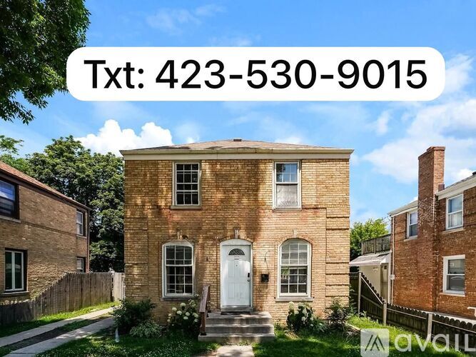 A brick house with a white door and windows is for sale.
