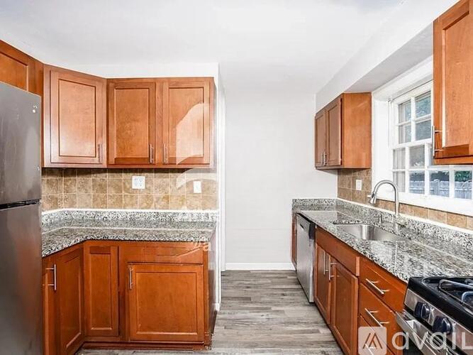 A kitchen with wooden cabinets and a granite countertop.