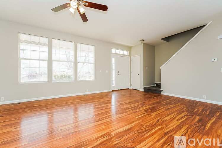 A room with a ceiling fan and tiled flooring.