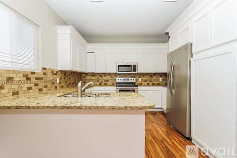 A kitchen with a refrigerator, microwave, and oven.