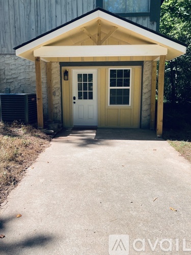 A small wooden building with a white door and window.