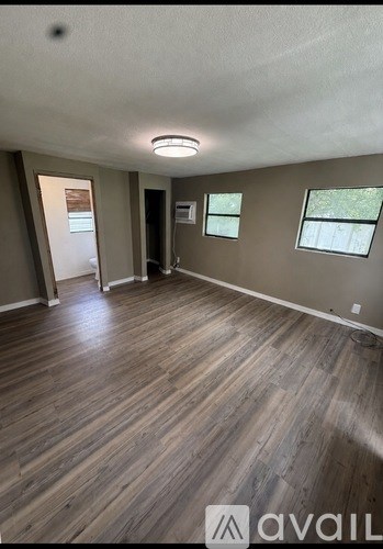 A room with wooden flooring and a window.