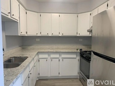 A kitchen with white cabinets and a stainless steel oven.