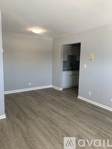 A room with a kitchenette in the back and Avail logo on the floor.