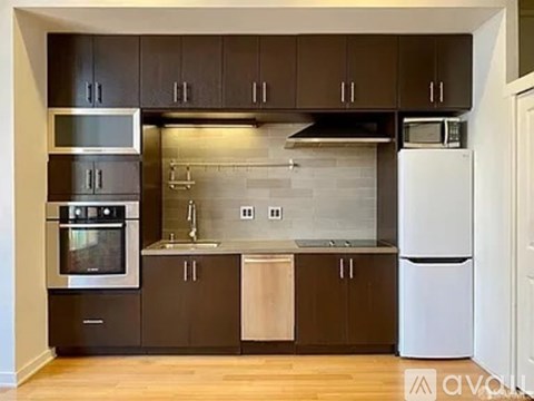 A kitchen with dark brown cabinets and stainless steel appliances.