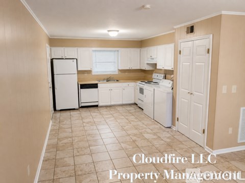 A kitchen with white appliances and beige walls.