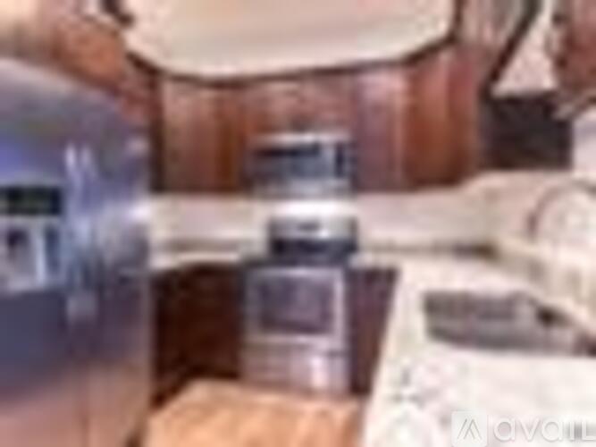 A kitchen with a stainless steel refrigerator and a wooden counter.
