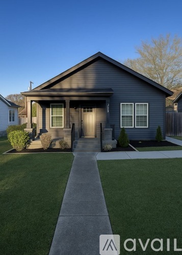 A house with a grey front yard and a concrete walkway leading to the front door.