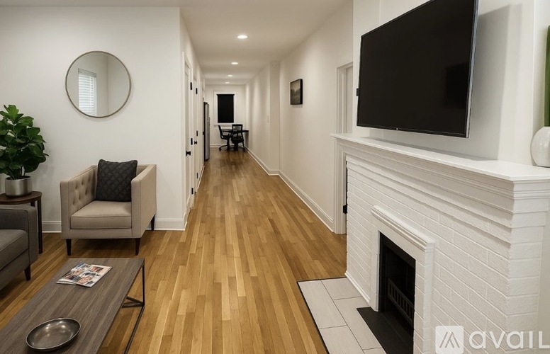 A long hallway with a fireplace and a television on the wall.