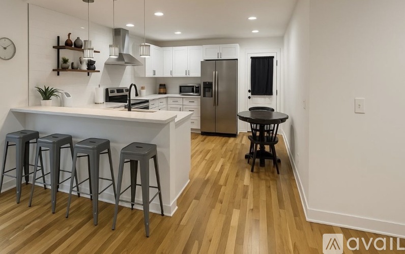 A kitchen with a white counter and grey stools.