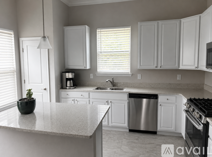 A kitchen with white cabinets and a granite countertop.