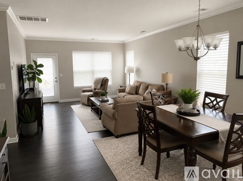 A well-lit living room with a dining table and chairs.