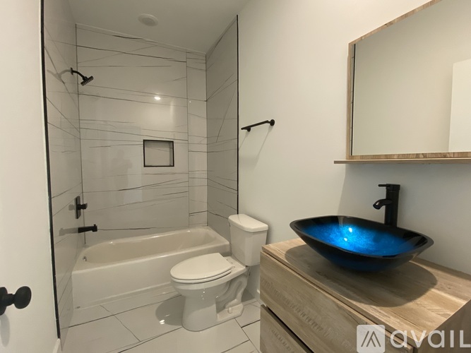 A bathroom with a white tub, toilet, and sink.