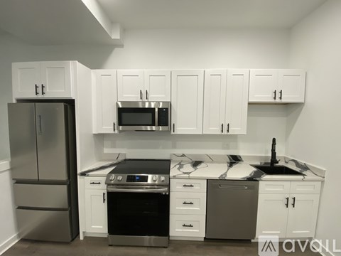 A kitchen with white cabinets and stainless steel appliances.