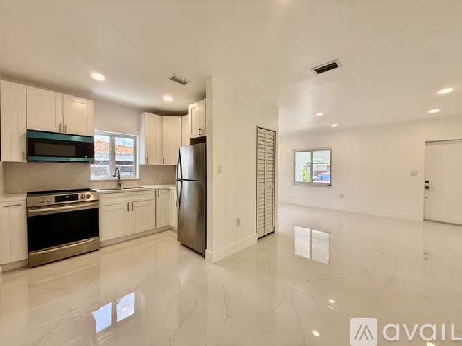 A spacious kitchen with white cabinets and stainless steel appliances.