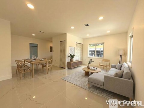 A well-lit living room with a dining table and a couch.