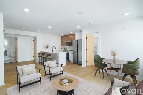 A modern living room with a dining area and kitchen in the background.