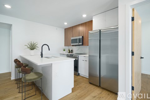 A modern kitchen with a white island and stainless steel appliances.