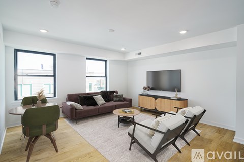 A living room with a couch, chairs, and a television.