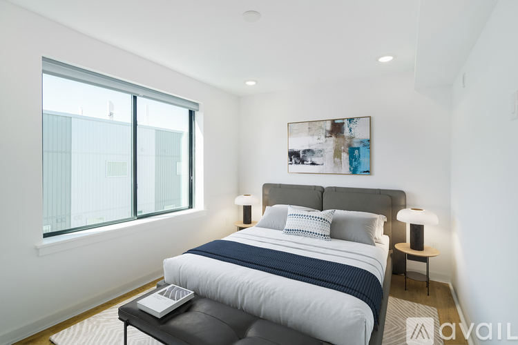 A bedroom with a large bed and a laptop on the coffee table.