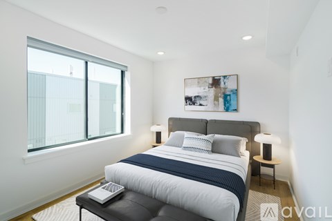 A bedroom with a large bed and a laptop on the coffee table.
