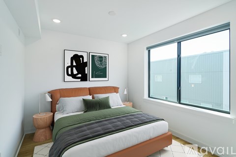 A bedroom with a large bed and two framed pictures on the wall.