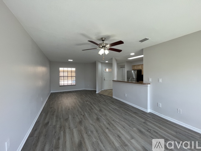 A spacious room with a ceiling fan and lighting fixtures.