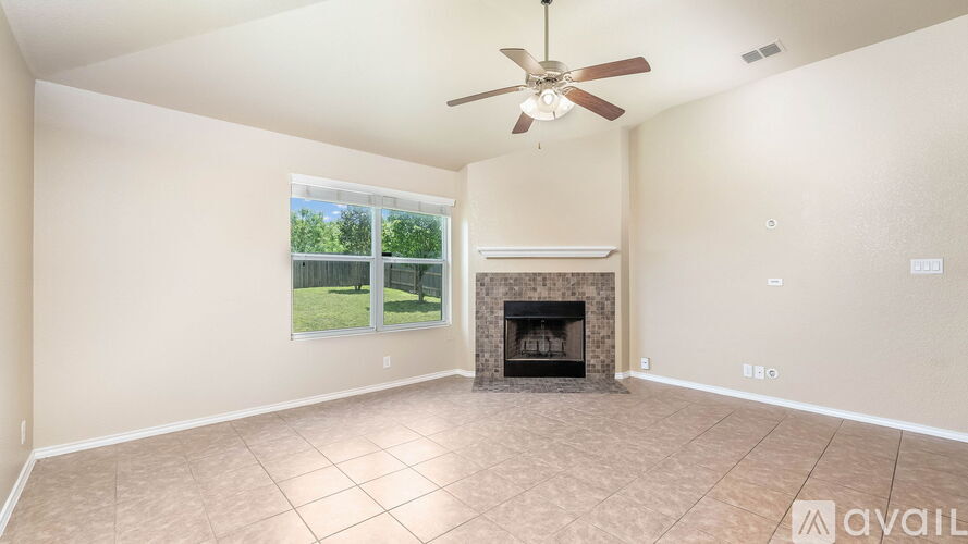 A living room with a fireplace and a ceiling fan.