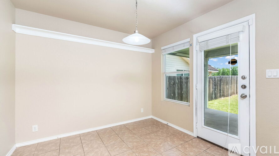 A room with a sliding glass door leading to a backyard.