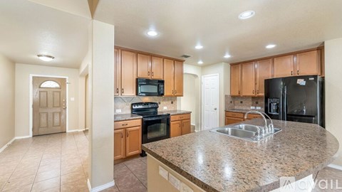 A kitchen with a granite countertop and stainless steel appliances.